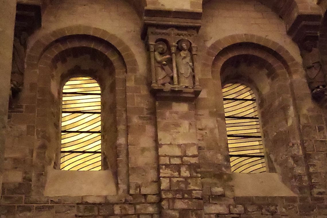 Les vitraux de Soulages à Conques prennent une teinte orangée sous l'éclairage public.
