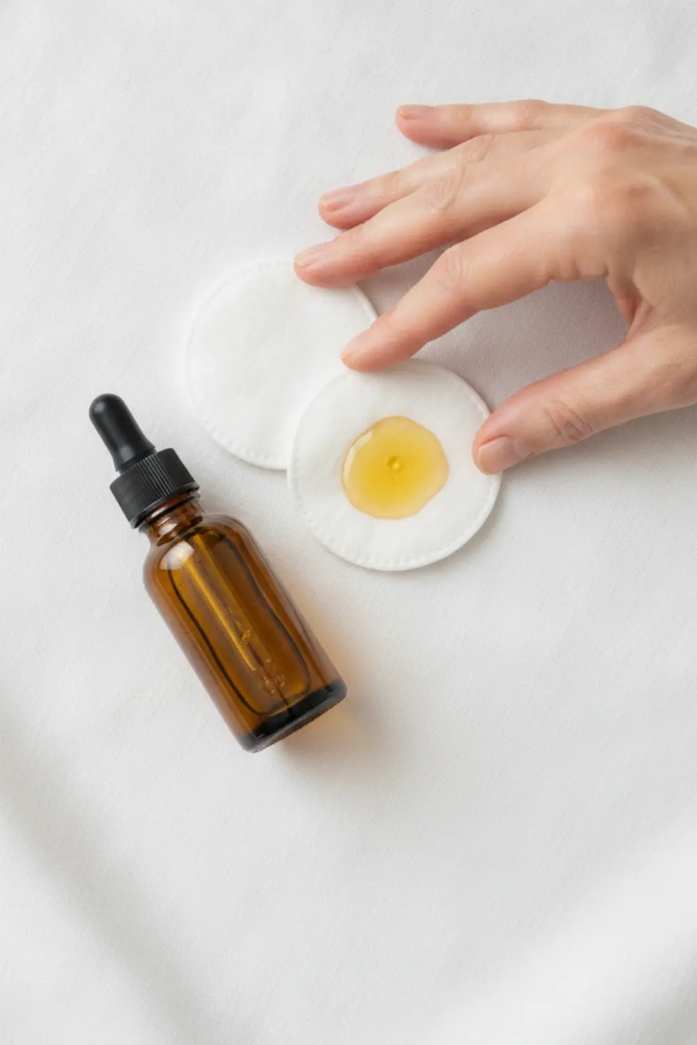 Faux ongles : comment choisir ceux qui tiennent sans abîmer vos ongles naturels 4 Flacon d’huile de ricin et coton pour masser les ongles naturels après retrait des faux ongles