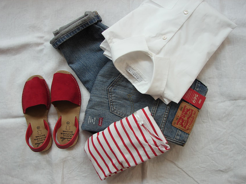 Chaussures rouges, chemise et jean sur un drap blanc