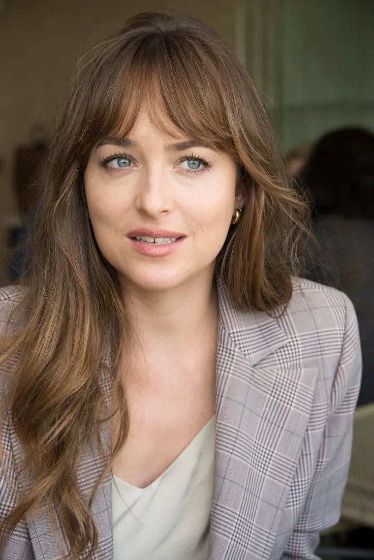 La frange sous toutes ses formes : un intemporel 5 Dakota Johnson Frange dégradée asymétrique longue yeux bleus
