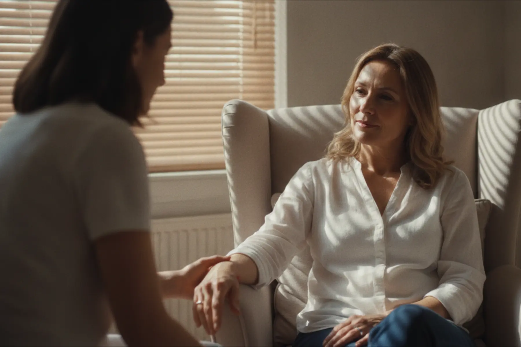 Ostéopathie : ce qui se passe vraiment lors d’une séance 1 Femme de 45 ans assise calmement lors d'une consultation chez un ostéopathe, intérieur lumineux et chaleureux.