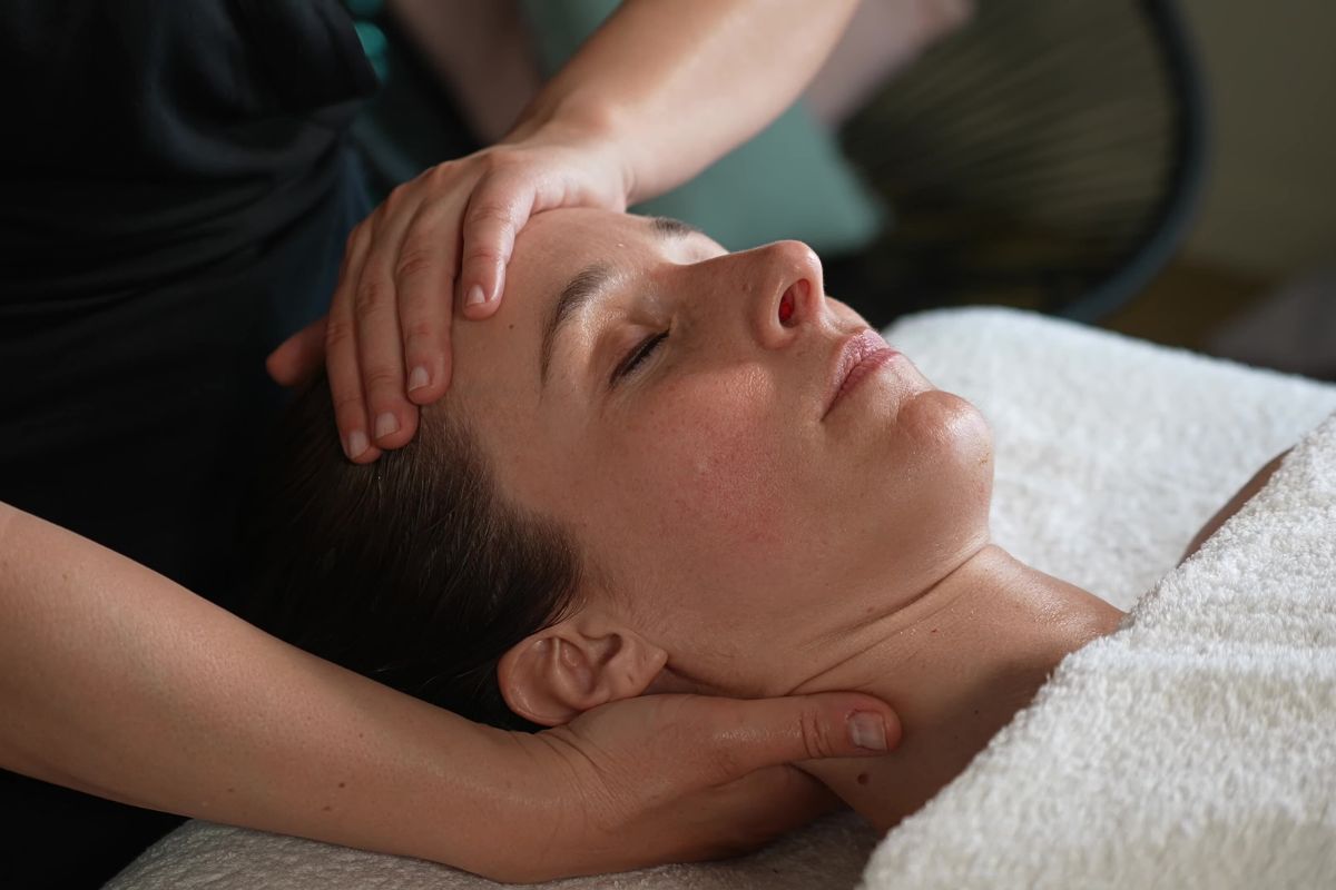 Soins anti-âge : femme recevant un massage hollistique du visage et du cou.

