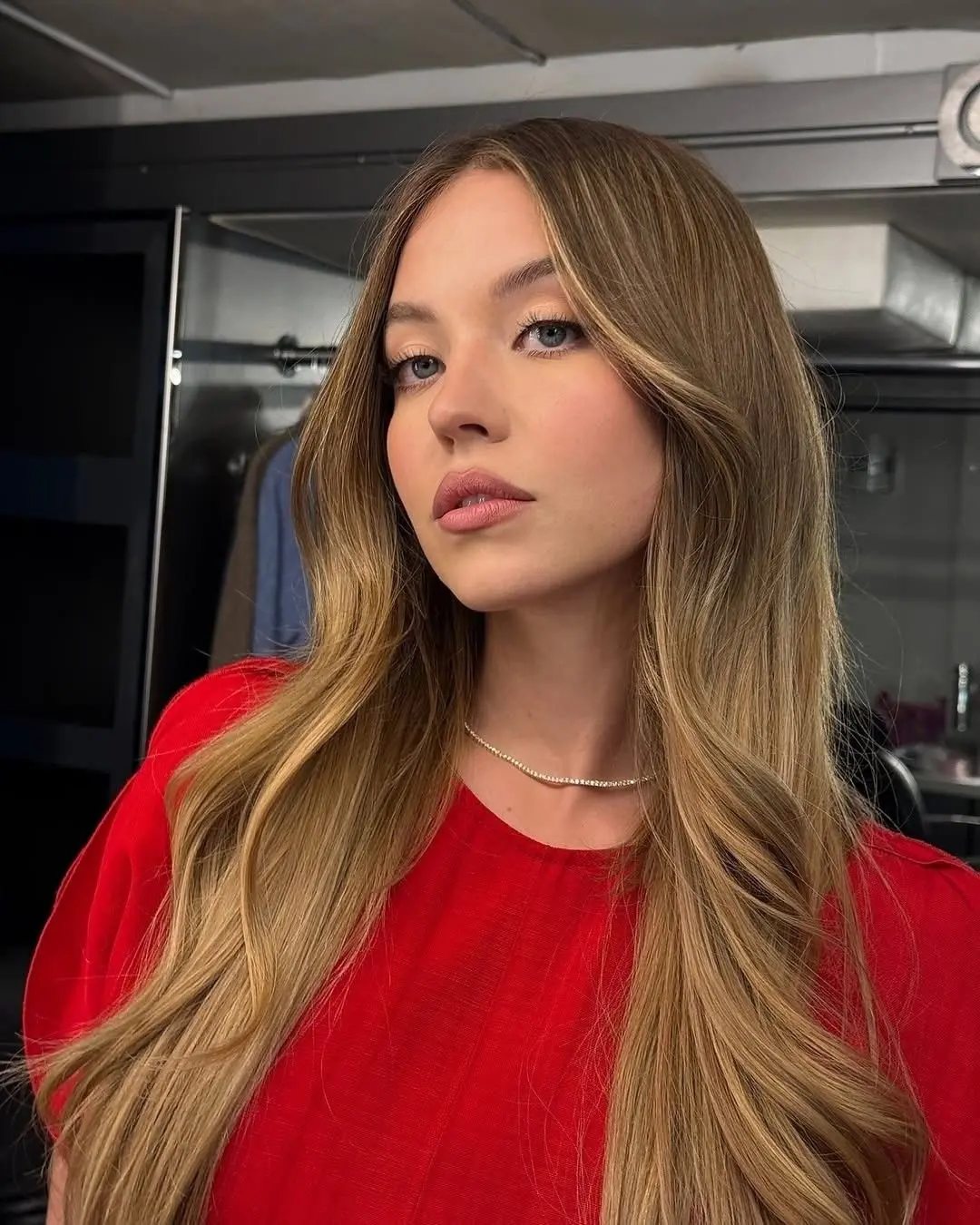 Sydney Sweeney cheveux blonds longs dégradé butterfly cut maquillage naturel