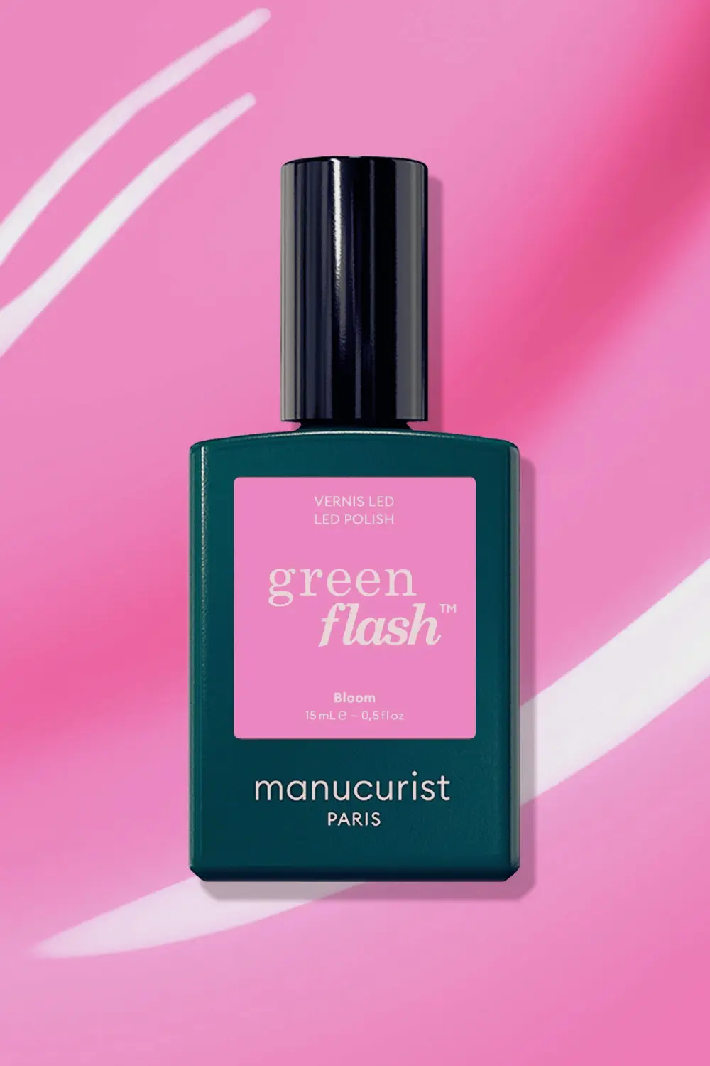 Vernis semi-permanent sans danger : les marques à privilégier 2 Flacon de vernis à ongles LED Green Flash de Manucurist Paris teinte Bloom sur fond rose.