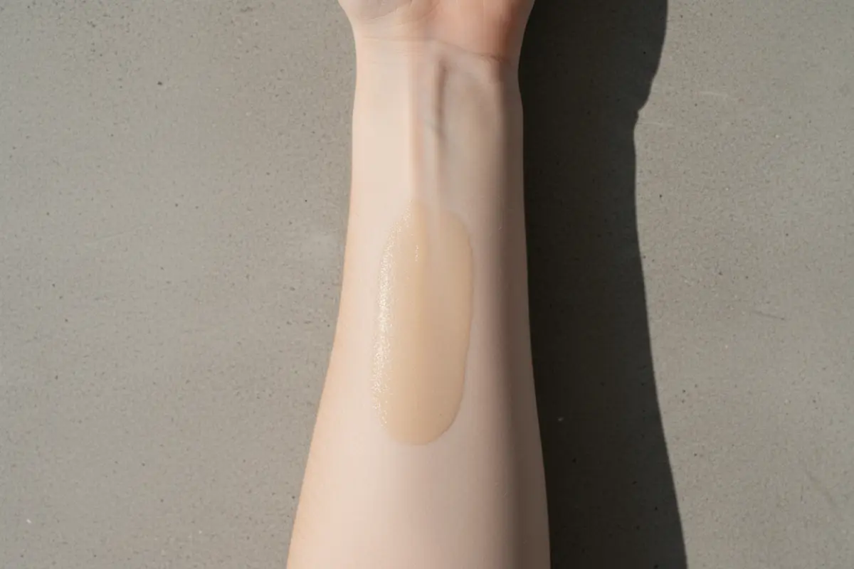 Avant-bras féminin après application d’une huile pour visage, aspect mat et non gras, peau réelle texture visible.