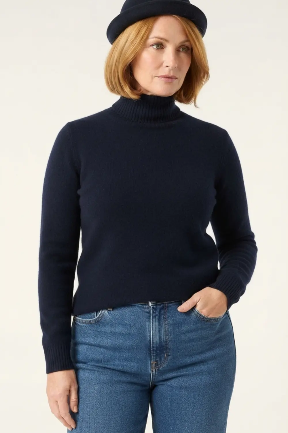 Femme portant un pull à col roulé bleu marine Parksville de Loro Piana et un jean.