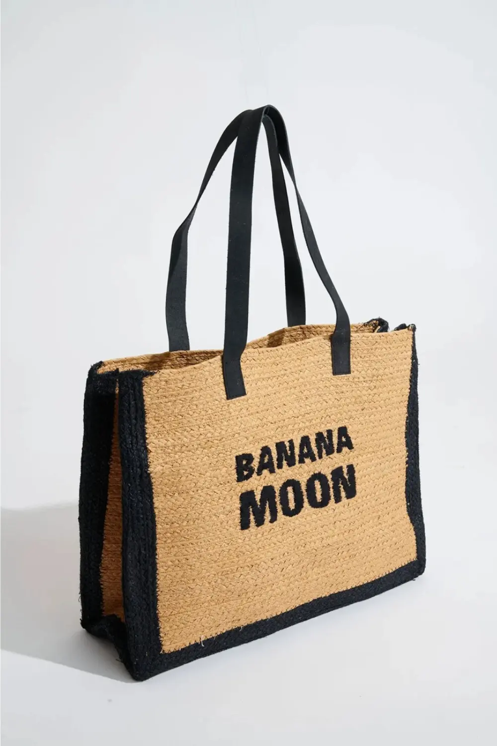 Sac cabas en raphia noir Banana Moon, modèle KARNAK HABRA, posé sur une surface claire