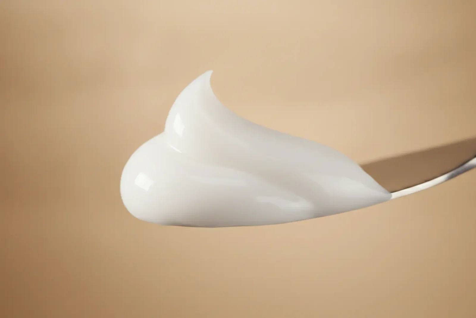 Avène Hyaluron Activ Procedure : test du rétinal sur peau mature 3 Macro détail de la texture crémeuse abricotée du soin au rétinal Avène Hyaluron Activ Procedure sur une spatule, lumière studio douce, style éditorial beauté